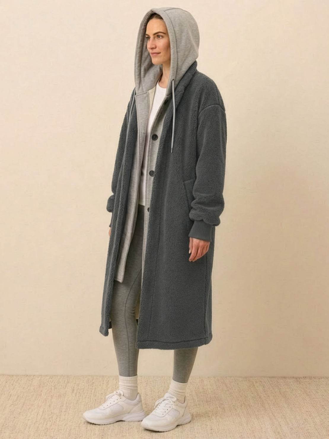 Woman wearing a cozy gray oversized sherpa long coat with hood, layered over casual outfit, perfect everyday wear oversized coat for warmth and style.