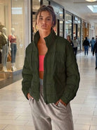 woman wearing olive green lightweight puffer travel jacket in shopping mall