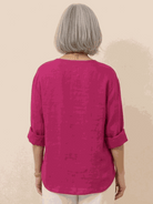 White pure linen age-defying shirt with button details on hanger against white background
