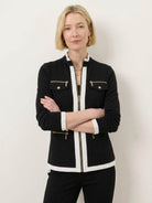 Woman wearing sleek black contrast zip two-piece outfit against white background