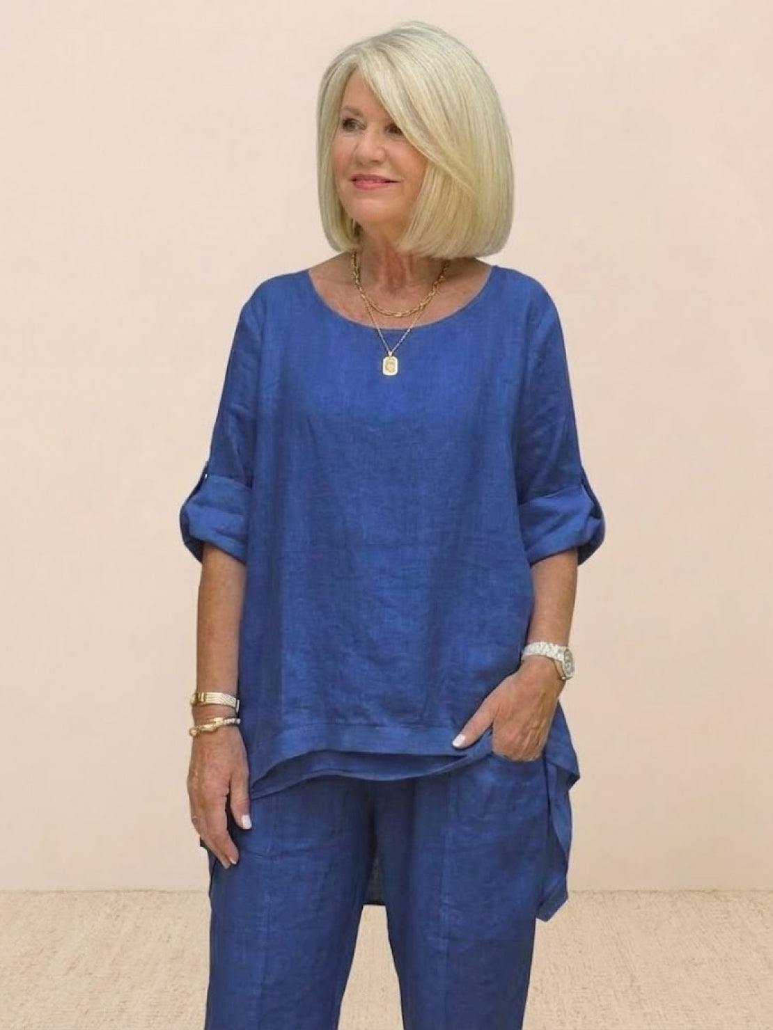 Woman wearing a royal blue asymmetrical two-piece trouser set with rolled-up sleeves and loose fit