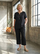 Woman wearing breezy cotton blend two-piece set with short-sleeve shirt and elastic waist pants