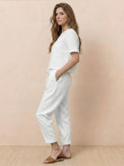 Woman wearing relaxed cotton linen set with short-sleeve top and straight-leg pants in monochrome tone