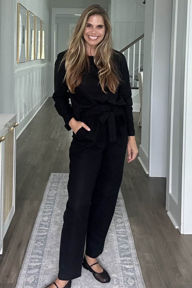 Woman wearing black relaxed fit cotton-linen monochrome longline top and wide-leg pants set in modern minimalist style