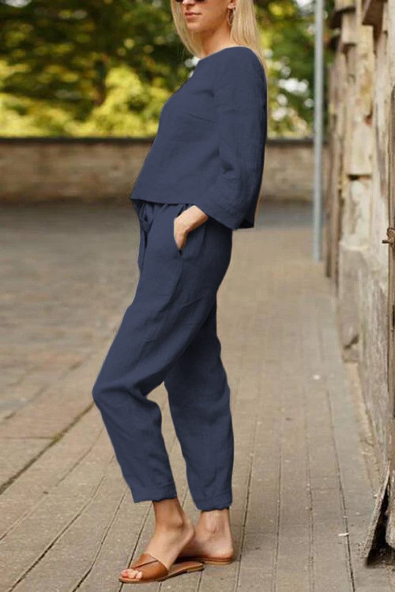 Woman wearing navy cotton-linen monochrome relaxed longline top and wide-leg pants, casual street style.