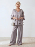 Woman wearing Elegant Layers two-piece set with layered V-neck top and matching pants in a neutral color