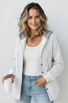 woman wearing white textured Highland Plaid Shacket with gray hood and white tank top holding coffee cup