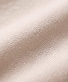 Close-up of soft lightweight beige cotton fabric for short-sleeved pullover and wide trouser matching set