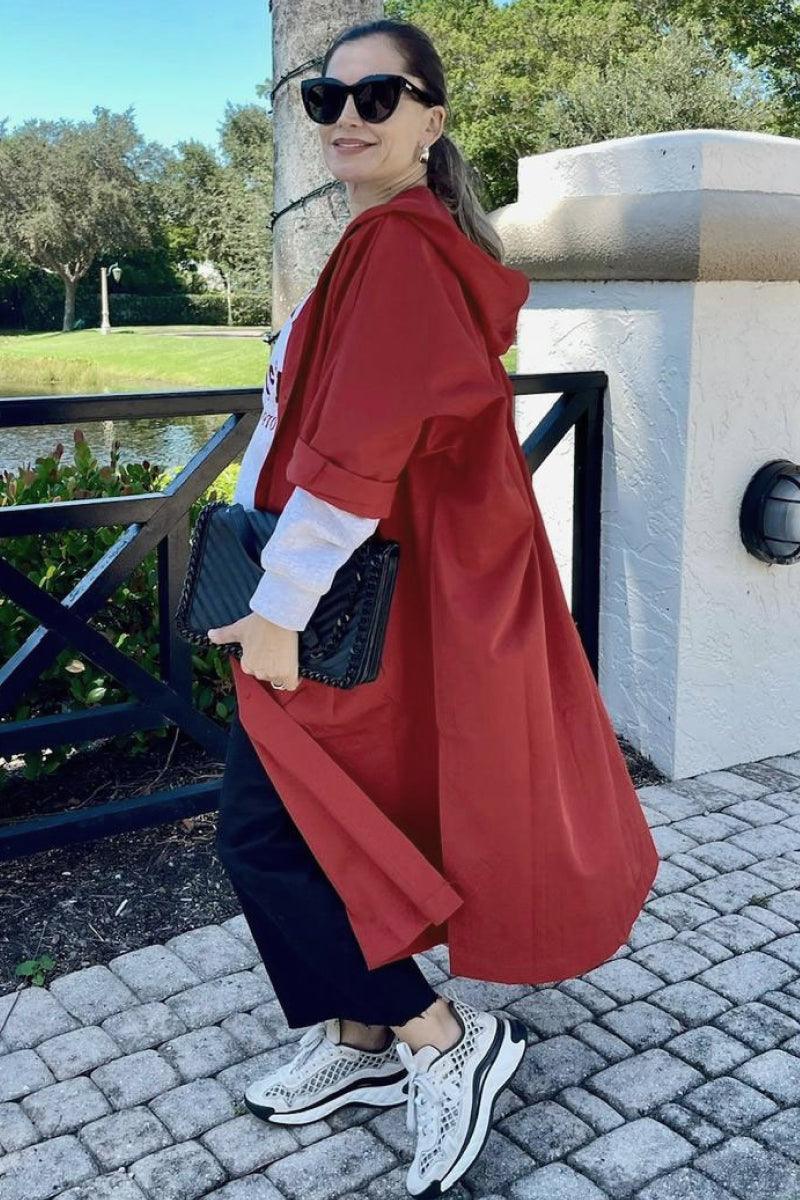 Woman wearing oversized one-size heritage windbreaker jacket in red with hood outdoors