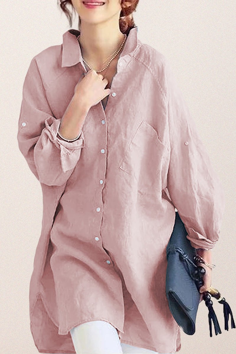 Oversized linen shirt in sun-washed pink with relaxed fit and button details, styled with white pants and a blue clutch.
