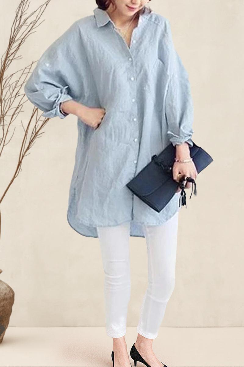 Light blue oversized linen shirt with relaxed fit and button front, styled with white pants and black heels.