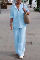 Woman wearing oversized 100% cotton light blue shirt and wide-leg pants co-ord set walking outdoors