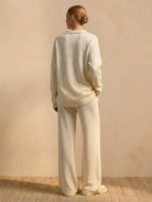 Back view of woman wearing Plush & Preppy Camel Two-Piece Set with relaxed wide-leg pants and long-sleeve pullover against beige background