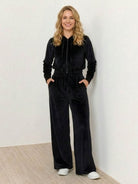 Woman wearing modern cropped velour tracksuit with high-waist pants in vibrant color