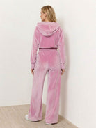 woman wearing modern cropped velour tracksuit with high-waist pants in vibrant color