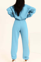 Woman wearing light blue cotton blend tracksuit with elastic waistband and cuffs viewed from back