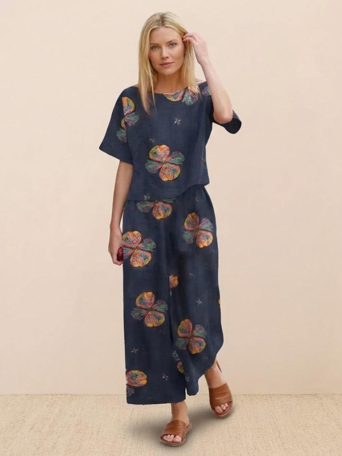 Woman wearing loose fit co-ord set with floral prints and wide-leg trousers.
