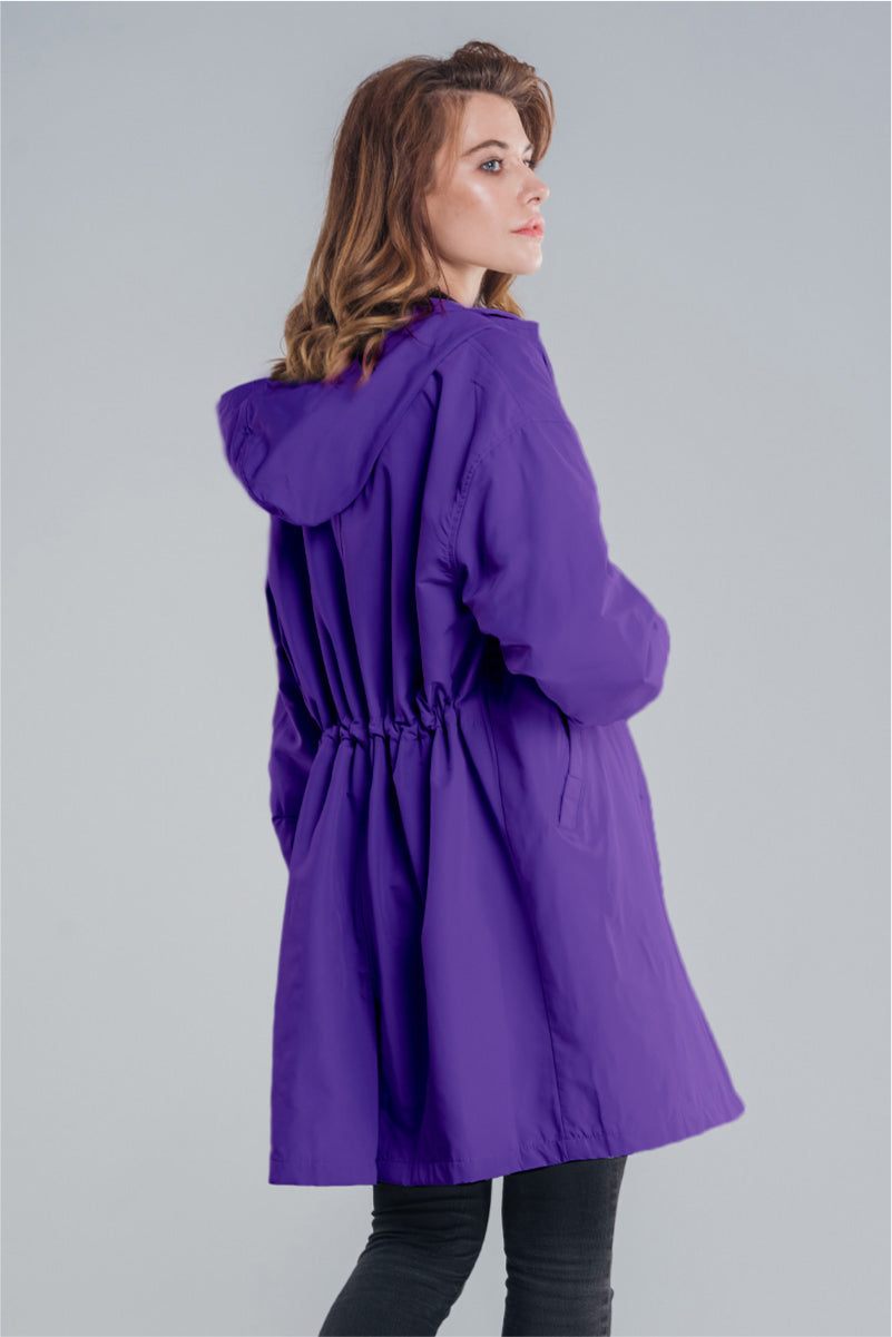 Woman wearing a purple oversized Rain Couture Windbreaker with hood and adjustable waist back view