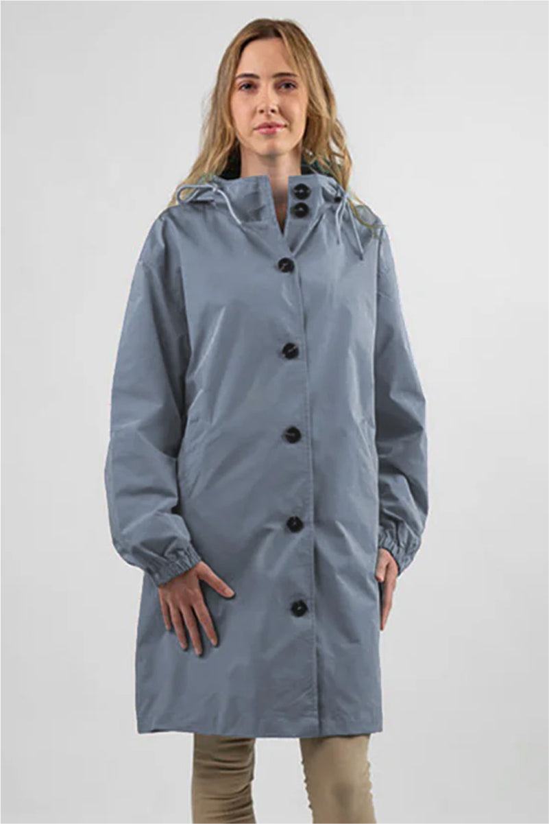 Woman wearing oversized blue Rain Couture Windbreaker water-resistant jacket with hood and button closure