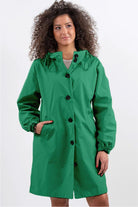 Green oversized Rain Couture Windbreaker jacket with hood and button closure on model