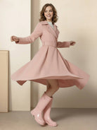 Woman wearing water-repellent A-line hooded raincoat with belt, standing outdoors in rainy weather