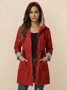 woman wearing red water resistant windbreaker with hood and striped cuffs