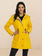 woman wearing yellow water resistant windbreaker with hood and front pockets