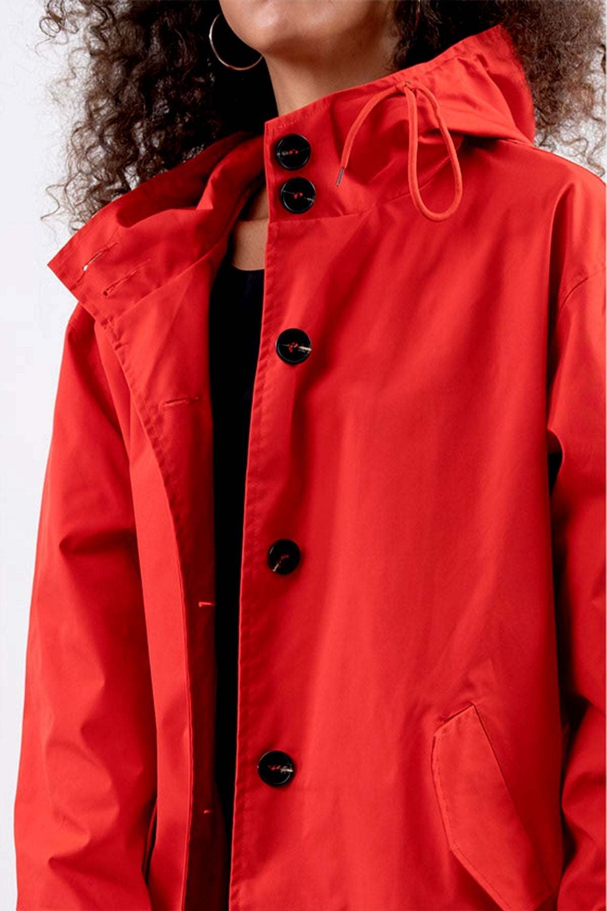 Red Rain Couture Windbreaker with oversized fit, water-resistant fabric, adjustable hood, and large black buttons.